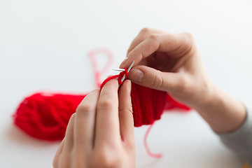 Image showing close up of hands knitting with needles and yarn