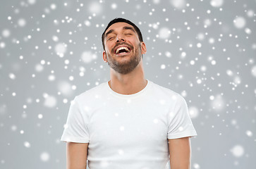 Image showing happy laughing man over snow background