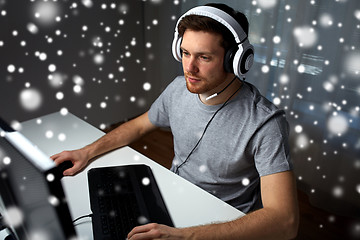 Image showing man in headset playing computer video game at home