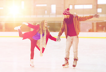 Image showing happy couple holding hands on skating rink