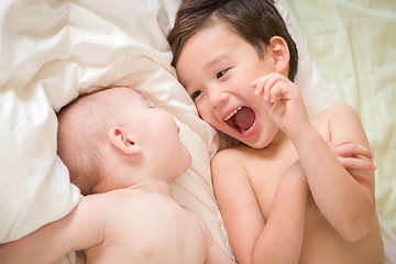 Image showing Mixed Race Chinese and Caucasian Baby Brothers Having Fun Laying