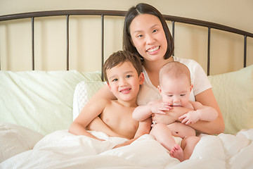 Image showing Mixed Race Chinese and Caucasian Baby Boys Laying In Bed with Th