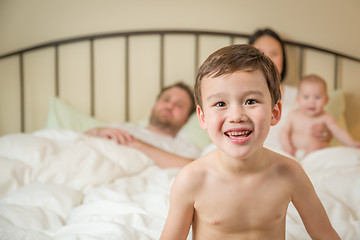 Image showing Mixed Race Chinese and Caucasian Boy Laying In Bed with His Fami