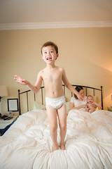 Image showing Mixed Race Chinese and Caucasian Boy Jumping In Bed with His Fam