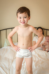 Image showing Mixed Race Chinese and Caucasian Boy Jumping In Bed with His Fam