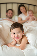 Image showing Mixed Race Chinese and Caucasian Boy Laying In Bed with His Fath