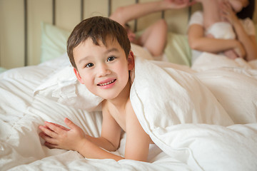 Image showing Mixed Race Chinese and Caucasian Boy Laying In Bed with His Fath