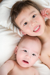 Image showing Mixed Race Chinese and Caucasian Baby Brothers Having Fun Laying