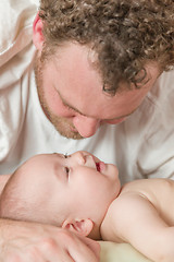 Image showing Mixed Race Chinese and Caucasian Baby Boy In Bed with His Father