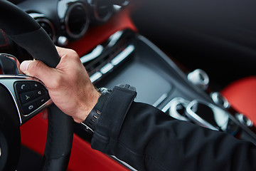 Image showing Male driver hands holding steering wheel.