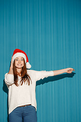 Image showing Surprised christmas girl wearing a santa hat