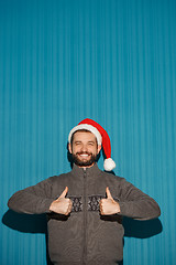 Image showing Smiling christmas man wearing a santa hat