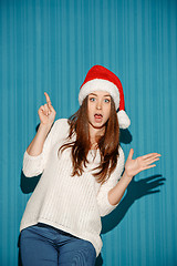 Image showing Surprised christmas girl wearing a santa hat