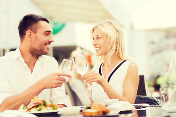 Image showing happy couple clinking glasses at restaurant lounge