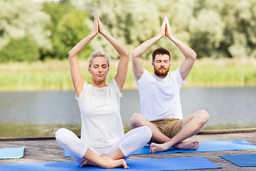 Image showing people meditating in yoga lotus pose outdoors