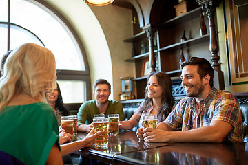 Image showing happy friends drinking beer at bar or pub