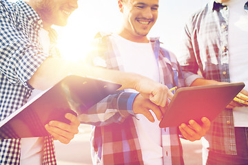 Image showing group of smiling builders with tablet pc outdoors