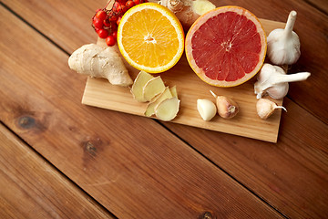 Image showing citrus fruits, ginger and garlic on wood