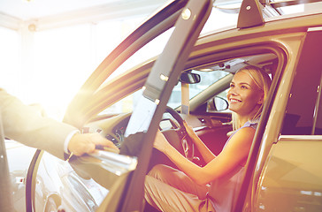 Image showing happy woman with car dealer in auto show or salon