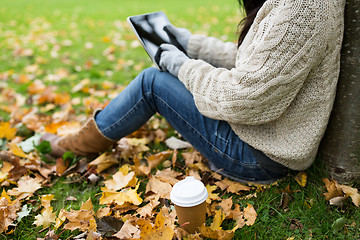 Image showing woman with tablet pc and coffee in autumn park