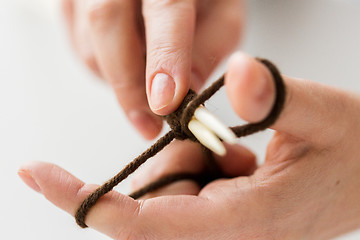 Image showing close up of hands knitting with needles and yarn