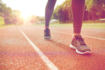 Image showing close up of woman feet running on track from back