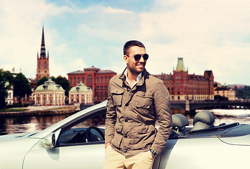 Image showing man near cabriolet car over city of stockholm