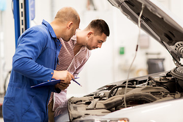 Image showing auto mechanic with clipboard and man at car shop