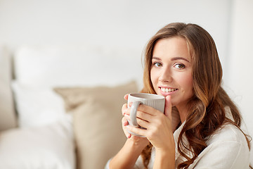 Image showing happy woman with cup of tea or coffee at home