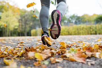 Image showing close up of young woman running in autumn park