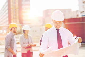 Image showing group of builders with tablet pc and blueprint