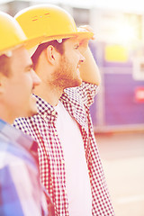 Image showing group of smiling builders in hardhats outdoors