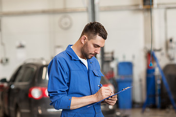 Image showing auto mechanic man with clipboard at car workshop