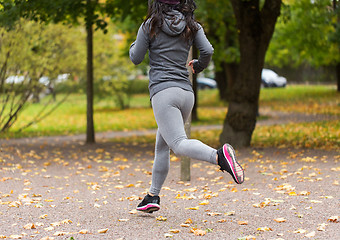 Image showing close up of young woman running in autumn park