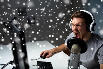 Image showing man in headset playing computer video game at home