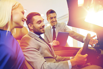 Image showing happy couple with car dealer in auto show or salon