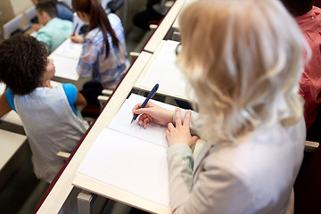 Image showing student writing to notebook at exam or lecture