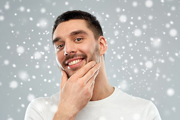 Image showing happy young man touching his face or beard