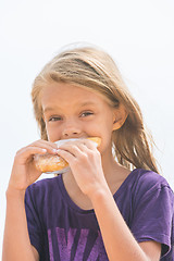 Image showing A hungry girl with an appetite for biting a delicious pie