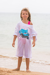 Image showing Girl poses funny faces standing on the beach in my father\'s shirt