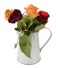 Image showing Four faded rose flowers in a metal jug