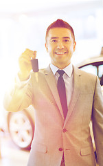 Image showing happy man showing key at auto show or car salon