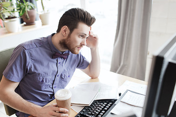 Image showing creative male worker with computer drinking coffee