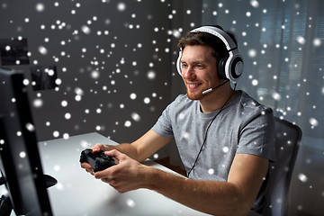 Image showing man in headset playing computer video game at home