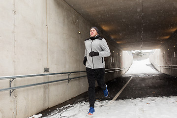 Image showing happy man running along subway tunnel in winter