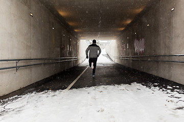 Image showing man running along subway tunnel in winter