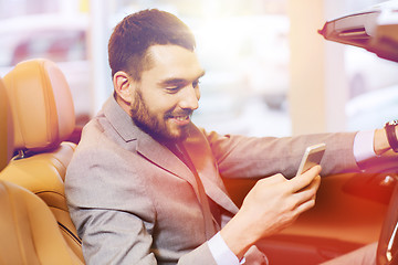 Image showing happy man sitting in car at auto show or salon