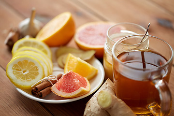 Image showing ginger tea with honey, citrus and garlic on wood