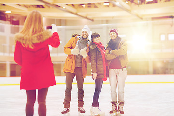 Image showing happy friends taking photo on skating rink