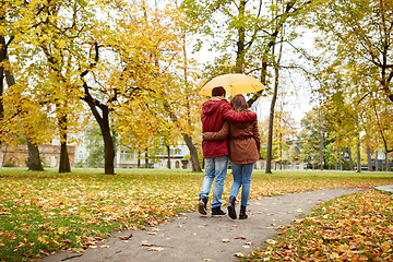 Image showing happy couple with umbrella walking in autumn park